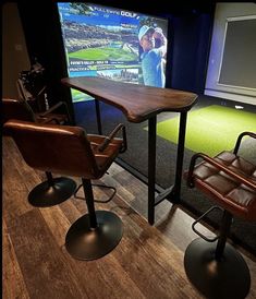 two chairs and a table are in front of a television with a golf game on it