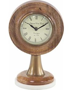 a small wooden clock with roman numerals on the face and hands, sitting on a white base