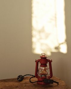 an old red lantern sitting on top of a wooden table