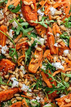 a salad with carrots, spinach and pine nuts is shown in close up