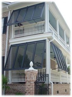 a large white house with black shutters and balconies