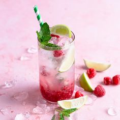 raspberry mojito with lime and mint garnish on pink background