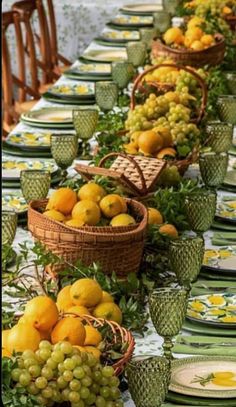 a long table topped with lots of plates and bowls filled with fruit on top of it