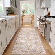 a large rug in the middle of a kitchen with white cabinets and drawers on both sides