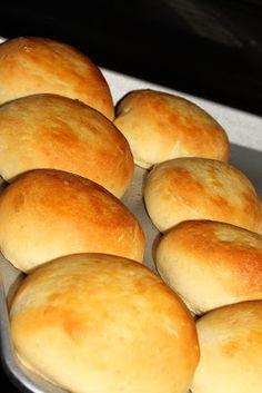 nine rolls in a metal pan sitting on top of a stove