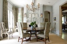 a formal dining room with chandelier and chairs