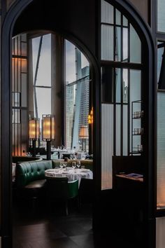 the interior of a restaurant with tables and chairs in front of large windows overlooking cityscape