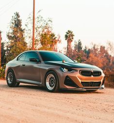 a brown car parked on the side of a dirt road