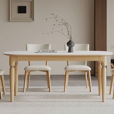 a table with four chairs and a vase on it