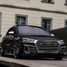 an audi suv parked in front of a building