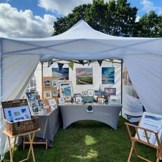 an outdoor tent set up with art on display