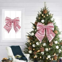 a decorated christmas tree with pink bows