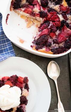 a slice of berry cobbler on a plate with a scoop of ice cream next to it