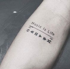 a person with a tattoo on their arm that reads music is life and arrows are in the background