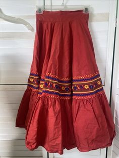 Handmade VTG Red Mexican Circle Skirt Bottom Ribbons Folkloric Jalisco Skirt XS Wide waist band with zipper and hook and eye closure. Two tiers. Bottom of the top tier has multi colored zig zag ribbons and embroidered thick ribbon. Opens to full skirt. Great for dancing and parties. Must be little and Small. Measurements taken laying flat Waist 11.5" Length 29.5" No flaws to note except for a small hole which is hard to find when worn. Could be fixed. A very uniquely made skirt. A true one of a Traditional Red Bottoms For Spring, Bohemian Red Full Skirt, Traditional Red Lined Skirt, Traditional Red Cotton Skirt, Traditional Red Flared Skirt, Red Bohemian Cotton Skirt, Bohemian Red Flared Skirt Bottoms, Bohemian Red Cotton Skirt, Bohemian Red Flared Skirt