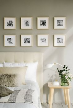 a bedroom with pictures on the wall above the bed and side table next to it