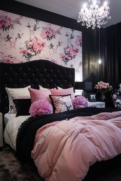 a black and white bedroom with pink flowers on the wall, chandelier and bedding