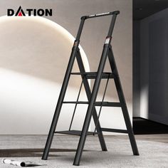 a black ladder leaning against a white wall in an empty room with other items on the floor