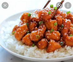 chicken and rice with chopsticks on the side in a white bowl, ready to be eaten