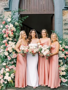 the bride and her bridesmaids pose for a photo in front of an archway with flowers