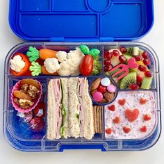 a blue lunch box filled with lots of different types of food and snacks in it