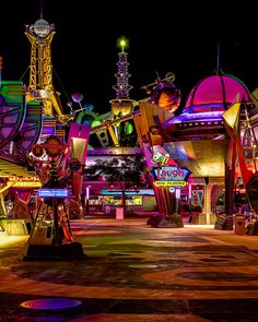 an amusement park at night with lights and rides