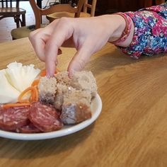 a person reaching for some food on a plate