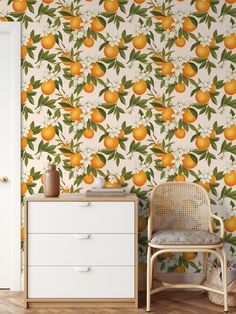 an orange wallpapered room with a white dresser and chair in front of it