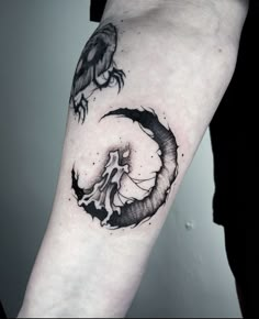 a black and white tattoo on the arm of a person with a bird sitting on top of it