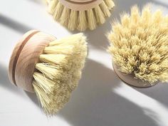 three different types of brushes sitting next to each other on a white surface with shadows