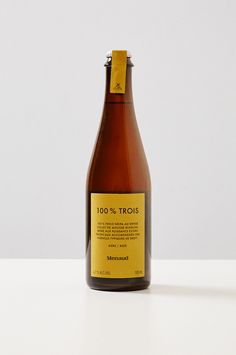 a brown bottle with yellow label sitting on top of a white table