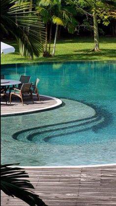 an empty swimming pool with chairs and umbrellas