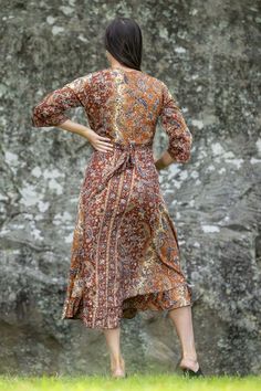 This luxurious Silk/Poly Blend Wrap Dress is the epitome of autumnal color. With its gently flowing ruffled skirt, long length, and bohemian gold embellishments, this dress is perfect for any special occasion. Let its beauty and charm make you shine like the autumn season. Bohemian Midi Boho Dress With Ruffles, Elegant Boho Print Maxi Dress For Festival, Elegant Long Sleeve Boho Print Maxi Dress, Brown Silk Dress For Fall, Brown Silk Dresses For Fall, Festive Fall Maxi Dress, Elegant Boho Print Festival Dress, Elegant Flowy Long Boho Dress, Elegant Long Flowy Boho Dress