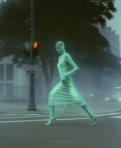 a woman in green is crossing the street