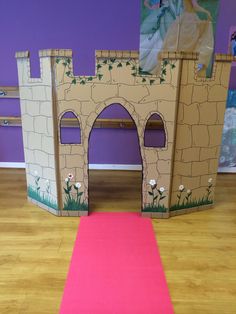 there is a pink carpet on the floor in front of a castle with a door