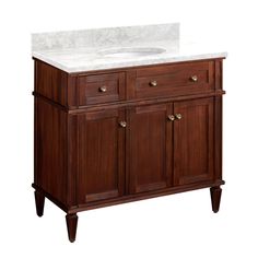 a bathroom vanity with a white counter top and wooden cabinet doors on the bottom side