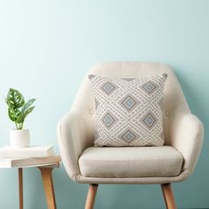 a chair with a pillow on it next to a potted plant