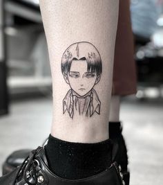 a person with a small tattoo on their leg that has an image of a man's face