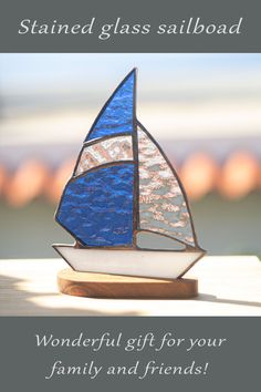 a stained glass sailboat sitting on top of a wooden table with the words wonderful gift for your family and friends