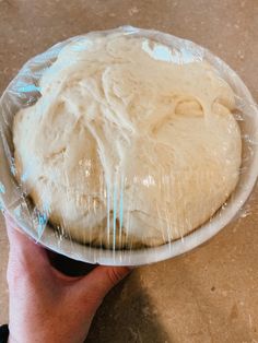 a person holding a plastic plate with dough in it