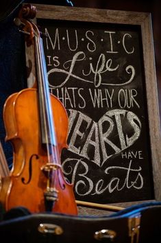 an image of a violin and some writing on the wall in front of a chalkboard