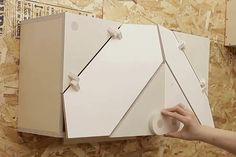 a person is holding an open box on the wall