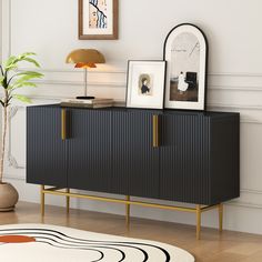 a black and gold sideboard in a living room with pictures on the top shelf