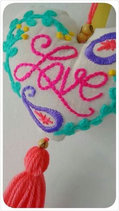 a heart shaped ornament with the word love hanging from it's side