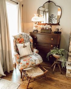 a living room with a chair, mirror and dresser