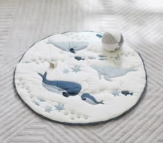 a blue and white round rug with dolphins on it