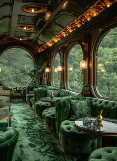 the interior of a train car with green couches and tables in front of large windows