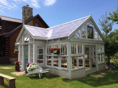 a house with a white roof and some flowers in the window boxes on the lawn