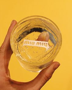 a hand holding up a glass with liquid in it on a yellow background that says, don't drink