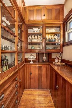 a kitchen with wooden cabinets and glass shelves